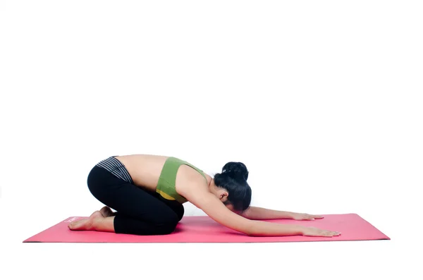Hermosa mujer haciendo ejercicio en interiores usando alfombra de yoga rosa — Foto de Stock