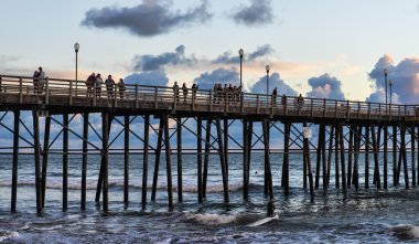 on Oceanside pier watching waves in the afternoon clipart