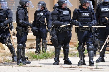 Polis memurları tam koruyucu giysiler içinde bir sivil huzursuzluk cevap verin.
