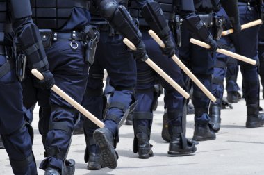Polis memurları tam koruyucu giysiler içinde bir sivil huzursuzluk cevap verin.