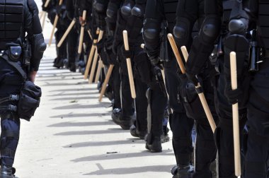 Polis memurları tam koruyucu giysiler içinde bir sivil huzursuzluk cevap verin.