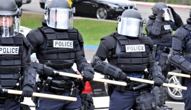 Moving toward the riot - police officers in protective gear clipart