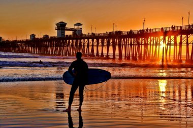 A silhouetted surfer waits for the perfect set clipart