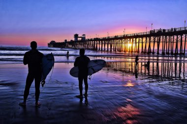 oceanside, california günbatımında Surfers