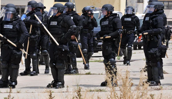 Agentes da Polícia em equipamento de proteção total respondem a uma perturbação civil — Fotografia de Stock
