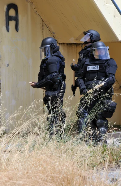 Gli agenti di polizia in completo equipaggiamento protettivo rispondono a un disturbo civile — Foto Stock