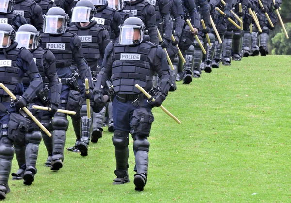 Show of force - police in riot gear move toward the civil unrest — Stock Photo, Image