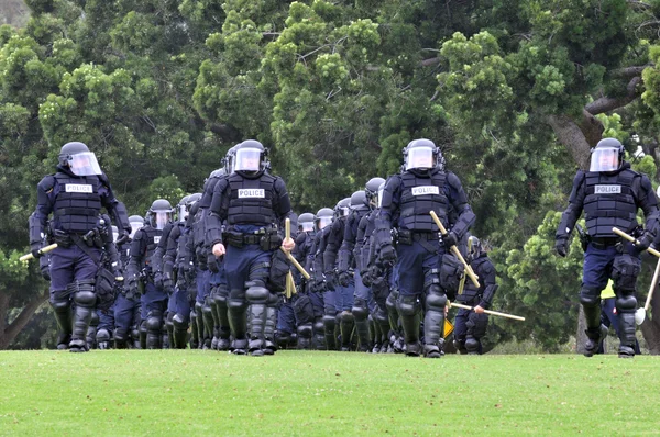 Auf die Randalierer zu - Polizisten in Schutzanzügen — Stockfoto