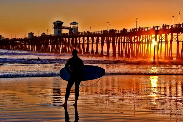 Ein silhouettierter Surfer wartet auf das perfekte Set — Stockfoto