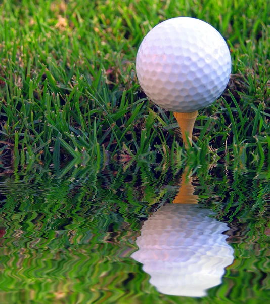¡Disparo difícil! Una pelota de golf en una camiseta en bruto y muy cerca de un peligro de agua — Foto de Stock