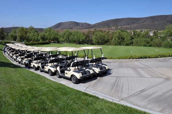 Reihe von Golfkarren - mehrere Paar Karren, die an einem strahlend blauen, sonnigen Tag in Südkalifornien auf eine Runde Golf warten. — Stockfoto