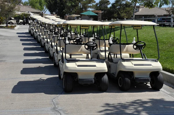 Reihe von Golfkarren - mehrere Paar Karren, die an einem strahlend blauen, sonnigen Tag in Südkalifornien auf eine Runde Golf warten. — Stockfoto