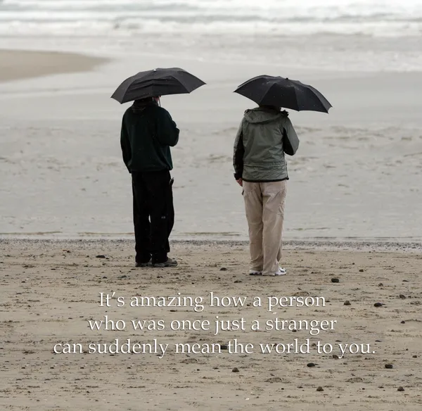 Friends on the beach with umbrellas — Stock Photo, Image