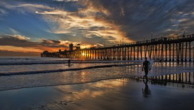 Surfers Walking Out Oceanside Pier Sunset clipart