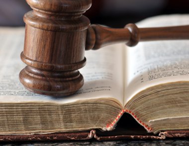 Gavel over weathered book in a portrayal of judicial system clipart