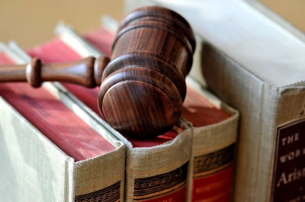 A wooden gavel atop books — Stock Photo, Image