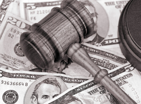 Wooden gavel atop US currency.