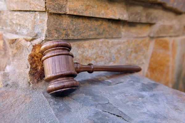 Gavel de madeira do juiz em uma parede de pedra — Fotografia de Stock