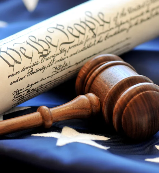 US constitution with wooden judge's gavel over American flag background — Stock Photo, Image