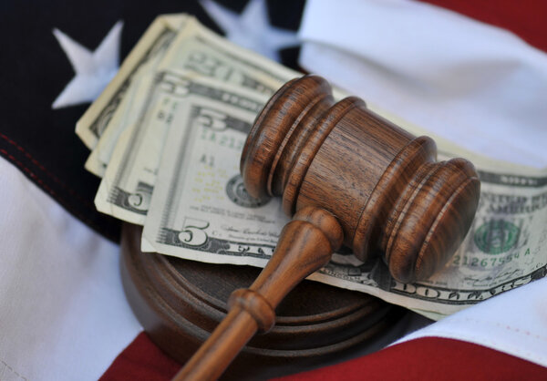 Gavel atop money and flag background
