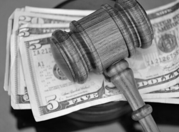 Wooden gavel atop US currency.