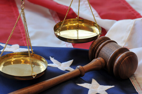 Gavel and scales atop flag background