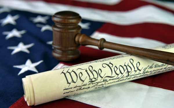 Constitución de Estados Unidos con mazo de juez sobre fondo de bandera estadounidense Fotos de stock libres de derechos