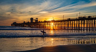 Gün batımında sörfçü. Oceanside, California, ABD 'de renkli bir gün batımı daha.