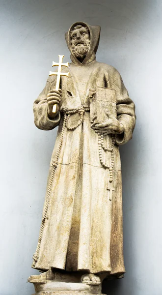 Statue of a saint with golden cross and bible — Stock Photo, Image