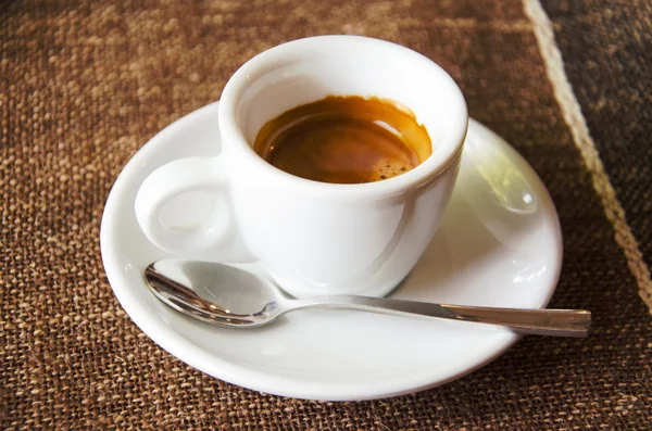 Kopp espresso över brun duk — Stockfoto