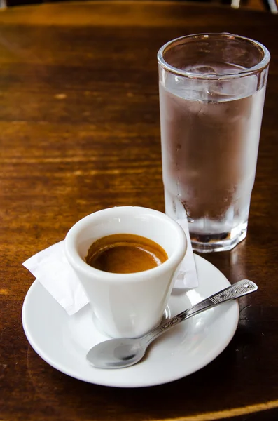 Белая чашка эспрессо со стаканом холодной воды — стоковое фото