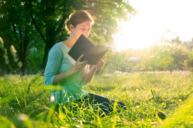 genç güzel kız parkta bir kitap okuma