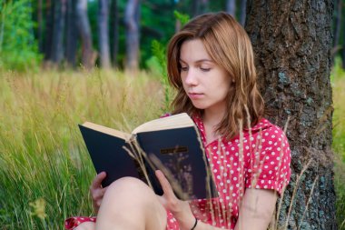 genç güzel kız parkta bir kitap okuma