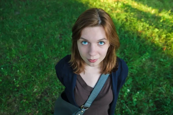 Jeune belle fille avec de grands yeux bleus debout dans le parc — Photo