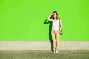 yeşil duvar ve zemin şapkalı genç güzel kız