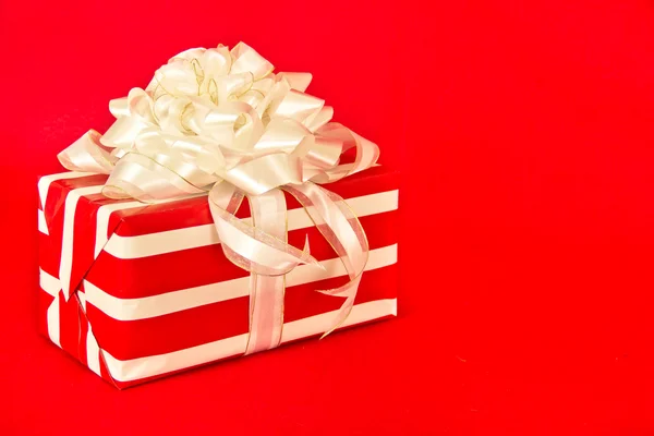 Красно-белый полосатый подарок с белыми лентами — стоковое фото