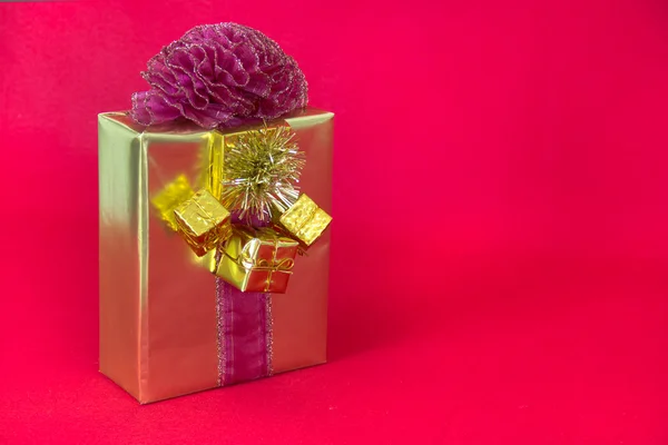 Gold-wrapped GIft with Curly Red Bow — Stock Photo, Image