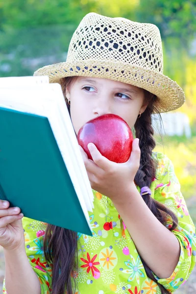 Chica con libro y manzana roja en el día de verano — Foto de Stock