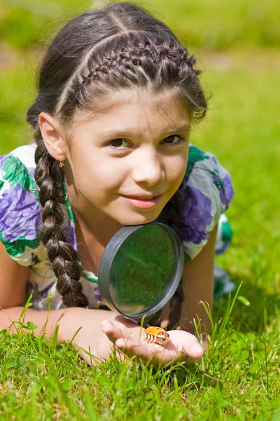 Smiling girl with magnifying glass — Stock Photo, Image