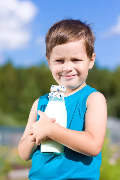 Smiling boy with bottle of milk — Stok Foto