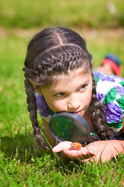 Kız çiçek üzerinde büyüteç aracılığıyla