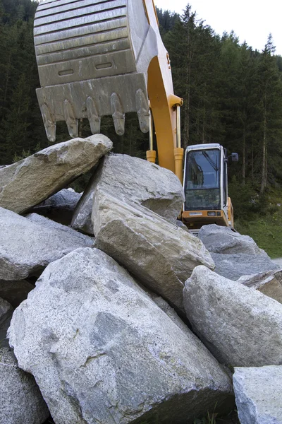 Excavator with stones — Stockfoto