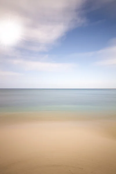 Deniz, plaj ve güneş arka, uzun süreli pozlama — Stok fotoğraf