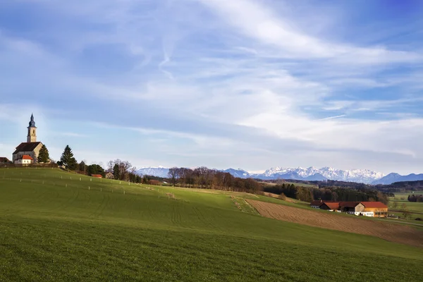 Typiska bayerska kyrkan med utsikt till Alperna — Stockfoto