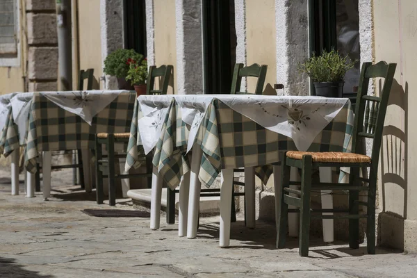 Стол и стулья перед рестораном в Греции — стоковое фото