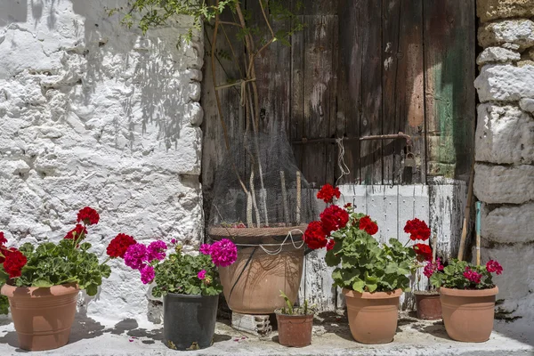 Macetas con flores frente a una casa antigua en Grecia — Foto de Stock