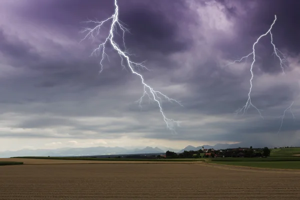 Blitz über einem kleinen Dorf in Bayern, Deutschland — Stockfoto