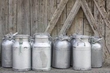Vintage milk cans in rural Northern Italy clipart