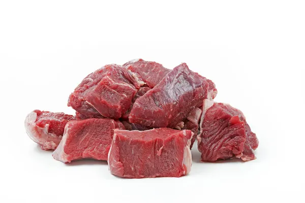 Bitar av rå nötkött gulasch, isolerad på vit — Stockfoto