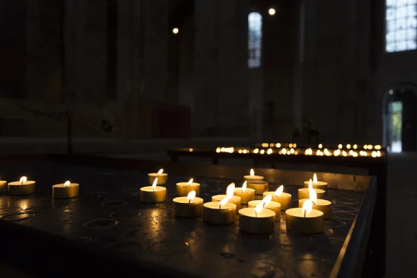 Small candles burning inside a church in Germany — Stock Photo, Image